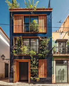 an apartment building with plants growing on the windows