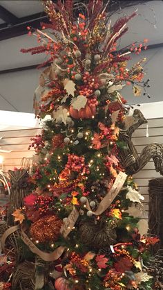 a decorated christmas tree with orange and gold decorations on the top is surrounded by other holiday decor