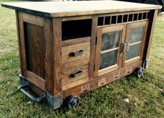 a wooden cabinet sitting on wheels in the grass