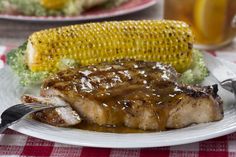 grilled pork chops and corn on the cob are served with gravy