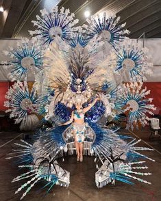 a woman standing on top of a stage with blue and white decorations