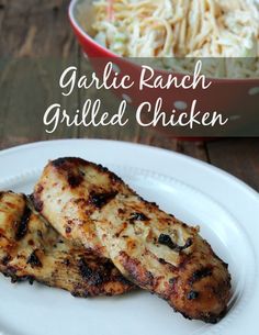 grilled chicken on a white plate next to a bowl of pasta