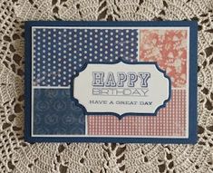 a happy birthday card with different colors and patterns on the front, sitting on top of a doily