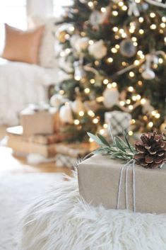 a christmas tree with presents under it and a pine cone on the present wrapper