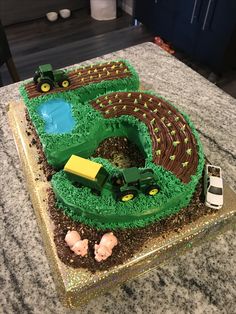 there is a cake that looks like a tractor and farm scene on the top of it