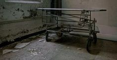 an old metal cart sitting in the corner of a room