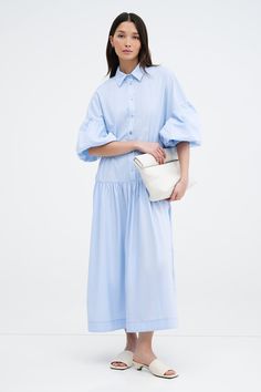 Meet our Ada Dress, the ultimate warm weather staple. She's a midi shirtdress handcrafted from 100% European poplin cotton, featuring pockets and a dropped gathered waistline that falls over your frame with ease. Her clean lines and sharp collar harmonize with dramatic dropped shoulders and full-bodied sleeves, elevating your style for any occasion.[SPLIT] Yada, in light blue, is 5'9" (175 cm) tall, wearing size XS. Shannon, in white, is 5'8" (173 cm) tall, wearing a size M. Maritza, in black an Cotton Maxi Dress With Gathered Sleeves For Summer, Cotton Button-up Maxi Dress For Daywear, Chic Poplin Dresses For Spring, Cotton Maxi Dress With Short Sleeves For Daytime, Spring Oversized Button-up Midi Dress, Oversized Spring Midi Dress With Button-up, Oversized Button-up Midi Dress For Spring, Daywear Midi-length Smocked Maxi Dress, Cotton Smock Midi Dress