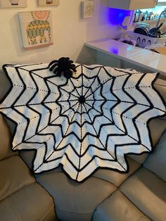 a spider web afghan sitting on top of a couch