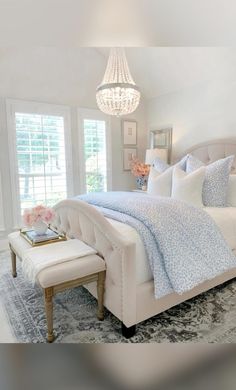 a white bed sitting in a bedroom next to a window