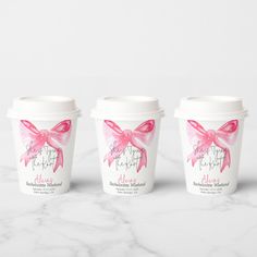 three coffee cups with pink bows on them sitting on a marble countertop next to each other