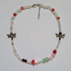 forest fairies necklace 🧚🏼‍♀️🌱

handmade, nature themed, whimsical beaded choker necklace (14 inches + 2 inches extender chain).

features: pink/green glass beads, red heart and mushroom glass charms, silver metal alloy dragonfly charms, acrylic pearl beads, rhodium silver finishings & 0.5mm elastic string.

(note: handle with care; do not stretch)

#fairycore #cottagecore #nature #mushroom Fairy Choker, Cottagecore Nature, Forest Fairies, Mushroom Fairy, Fairy Necklace, Dragonfly Charm, Glass Charms, Fairycore Cottagecore, Beaded Choker Necklace