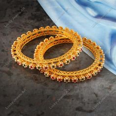 Features:- * An Indian styled Bangles. * Made from fine Quality Brass with Gold Platting. * Ready to be given as a gift. * Easy and Convenient way to Wear. * It looks prettier than the images. Direct Images on hand is also attached. Size of Bangles & Other Details:- * Gold Plated Pink, Green Stone & Pearl Flower Bangles * Size: You Select * Quantity: One Pair * Material: Fine Quality Brass with Gold Platting Choose your size from the drop down box SIZES AVAILABLE 2.4, 2.6 & 2.8 - 2.4 diameter 2.25" - 2.6 diameter 2.37" - 2.8 diameter 2.5" This gold plated unique Bangles is glamorously impressive, yet subtle, the design is clean and extremely accurate and suited to any kind of event, both formal and informal, featuring an amazing stones, this is one of my favorite items!  It looks beautiful Elegant Green Jeweled Bangle, Green Stone Bangles, Gold Ruby Bangle For Festive Occasion, Traditional Orange Bangle Bracelet, Ornate Gold Hand-set Bangle, Flower Bangles, Green Multi-stone Bangle Jewelry, Stone Bangles, Unique Bangle