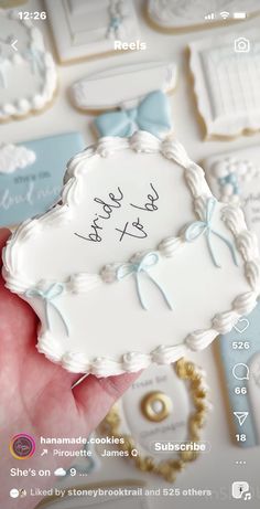 a hand holding a cookie with the words happy birthday written on it in blue and white icing