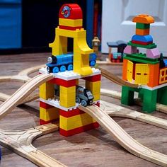 a toy train set is on the table with other wooden toys and accessories around it