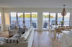 a living room filled with furniture next to a large window covered in lots of windows