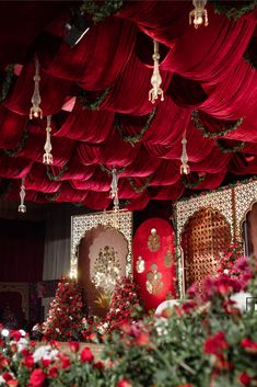 a room with red drapes and flowers on the ceiling, decorated in white and gold