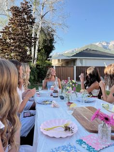 a group of women sitting around a table with plates and drinks in front of them