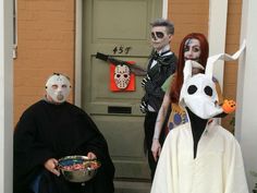 three people in halloween costumes standing outside with food and masks on their faces, one holding a bowl of candy while the other holds a knife