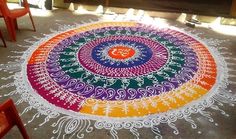 a colorful rangdi design is on the floor in front of chairs and red chairs