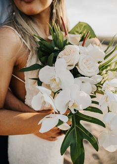 a woman holding a bouquet of white flowers