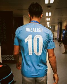 a man in a blue shirt walking down a hallway