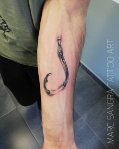 a man with a fishing hook tattoo on his arm