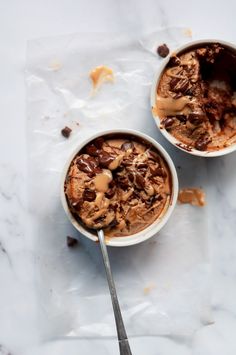 two bowls filled with ice cream and chocolate chips on top of a marble countertop