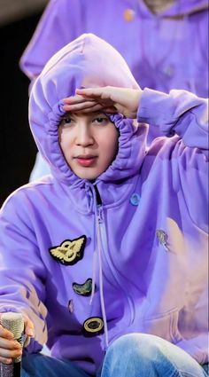 a boy in a purple jacket holding his head