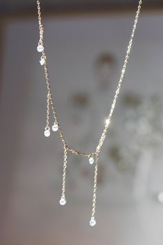 Faye Shooting Star Asymmetrical Fringe Gold Vermeil Necklace features tiny little cubic zirconia crystals set on 1 mm thick gold vermeil chain with a dainty asymmetrical fringe. Gorgeous alone or layered with friends. ◊ Asymmetrical Fringe ◊ 18k Gold Vermeil, Cubic Zirconias ◊ Length: 43 cm, adjustable length ◊ This is a made to order piece which will take 2-3 weeks to make, don't worry, we will will keep you in the loop and message you before we ship out! ◊ All of our jewelry is nickel-free ◊ D Long Charm Necklace With Adjustable Chain For Party, Minimalist Dangle Necklaces For Parties, Dainty Drop Necklace With Delicate Chain For Party, Elegant Gold Chain Necklace With Dangling Charms, Party Charm Necklaces With Dangle Clavicle Chain, Elegant Pendant Necklaces With Dangling Charms, Party Necklace With Delicate Dangle Chain, Party Dangle Necklaces With Delicate Chain, Dangle Drop Necklace With Adjustable Chain For Party