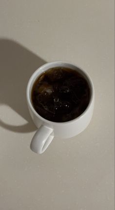 a white cup filled with liquid sitting on top of a table