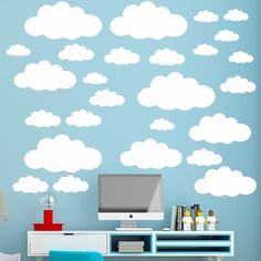 a room with a desk, computer monitor and clouds wall decal on the wall