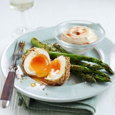 asparagus with an egg in the middle on a plate