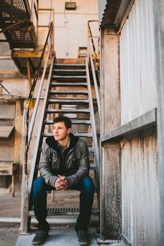 a man is sitting on the stairs in front of a building