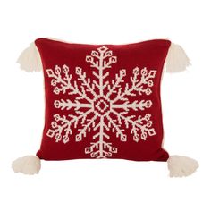 a red and white snowflake pillow with tassels