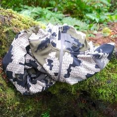 a bag is sitting on top of a mossy log