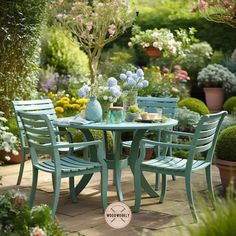 an outdoor table and chairs in a garden