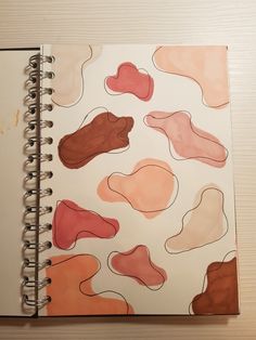 an open spiral notebook with different colored shapes on it