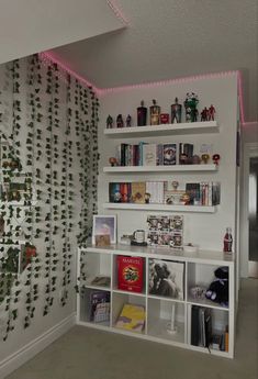 a living room filled with lots of white shelves and plants on the wall behind them