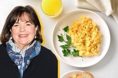 a woman sitting in front of a plate of scrambled eggs and two slices of bread