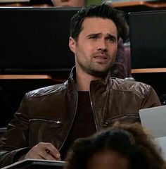 a man in a leather jacket is looking at something