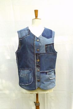 a mannequin wearing a blue jean vest with buttons and pockets on the front