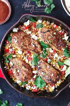 a skillet filled with chicken, corn and cilantro garnishes