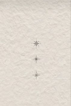 three snowflakes are shown in the middle of a white paper sheet with black ink