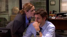 a man and woman kissing each other in an office