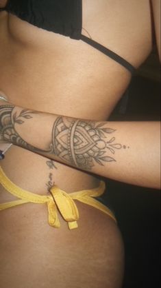 a woman with tattoos on her arm and leg is wearing a yellow tie around her waist