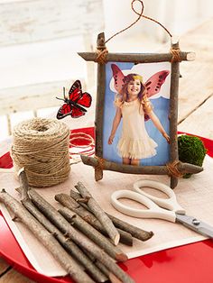 a table topped with scissors and twine next to a picture on a red plate