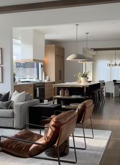 a living room filled with furniture next to a kitchen