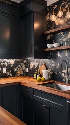 a kitchen with black cabinets and floral wallpaper on the backsplash is shown