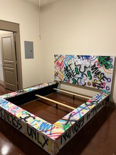 a bed with graffiti on it in an empty room