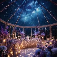 the inside of a wedding tent decorated with purple flowers, candles and stars in the sky